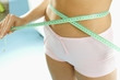 hand holding tape measure around waist (detail)