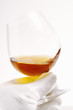hand in white glove holding glass of cognac