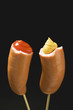sausages with ketchup & mustard on wooden cocktail sticks