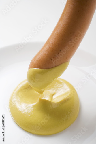 Photo: dipping a sausage in mustard dipping a sausage in mustard