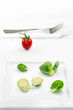 fresh Brussels sprouts, red tomato on white plate and fork fresh Brussels sprouts, red tomato on white plate and fork