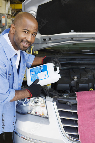 Foto: Auto Mechanic Adding Fluids to Minivan Auto Mechanic Adding Fluids to Minivan