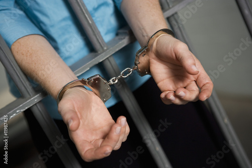Photo: Criminal handcuffed to bars in jail Criminal handcuffed to bars in jail