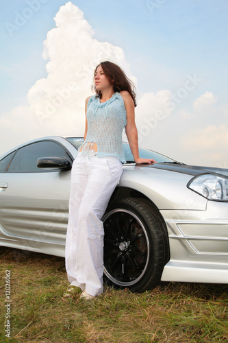 Photo: Woman stands having leant on a sport car Woman stands having leant on a sport car