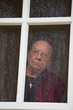 Photo: nachdenkliche Seniorin sieht traurig aus einem Fenster nachdenkliche Seniorin sieht traurig aus einem Fenster
