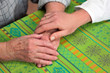 Hand einer Pflegerin und einer alten Seniorin