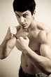 Muscular male fighter with fists ready to punch
