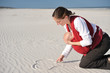 maman dessinant un coeur sur le sable