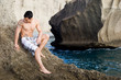 Modelo masculino posando sobre las rocas de la playa Modelo masculino posando sobre las rocas de la playa