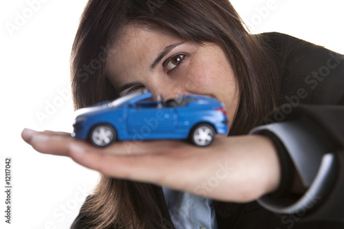 young businesswoman holding small car in the hand