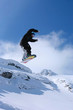 Male snowboarder jumping of a hill