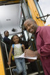 Teacher Unloading Elementary Students from School Bus