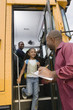 Teacher Unloading Elementary Students from School Bus
