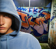 Cool looking hooligan in a graffiti painted gateway