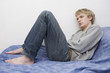 young blond sad man lying on the bed. young blond sad man lying on the bed.