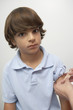 Nurse placing bandage on boy's arm