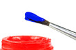 Pinsel mit blauer Farbe und rotem Farbtopf