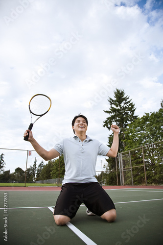 Photo: Asian tennis player in joy after winning Asian tennis player in joy after winning
