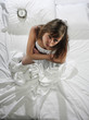 Woman in bed with alarm clock