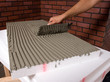 Apllying adhesive to insulation polystyren