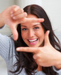 Portrait of happy young female making a snapshot sign