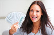 Portrait of excited young female holding money in the hand