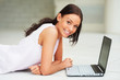 Portrait of young female lying down in front of laptop