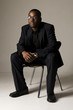black male sitting on a chair with hand clasped black male sitting on a chair with hand clasped