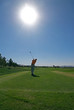 golfer teeing off into sun