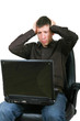 Businessman with laptop, holding head in hands