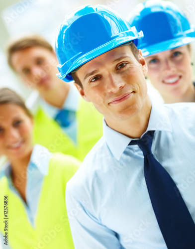 Photo: Group of successful construction workers standing together Group of successful construction workers standing together