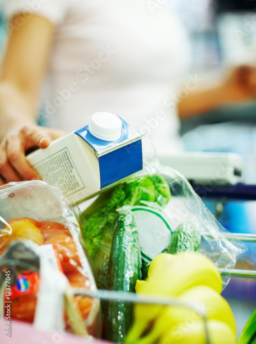Photo: Closeup of a grocery items being collected by a woman Closeup of a grocery items being collected by a woman