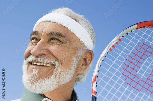 Photo: Senior man holding tennis racket Senior man holding tennis racket