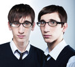 cute young twins with fashion haircuts wearing glasses