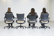 Rear view of business women sitting on office chairs.