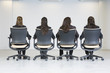 Rear view of business women sitting on office chairs.