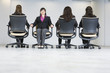 Business women sitting on office chairs.