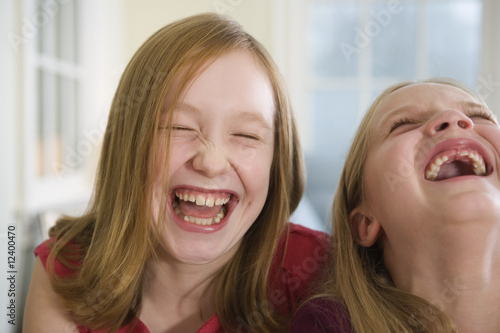 Photo: Close up of two sisters laughing. Close up of two sisters laughing.