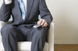 Midsection of a man holding mobile phone.