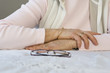 Midsection of a woman with glasses on a table.