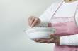 Midsection of a mature woman standing with a bowl.