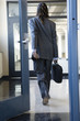 A young man walking through a doorway.