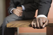 Close up of a businessman sitting on wooden desk.