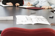 Photo: View of business women sitting with blueprints on the table. View of business women sitting with blueprints on the table.
