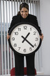 Portrait of a business woman holding wall clock.