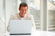 Smiling handsome man working on laptop