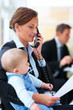 Foto: Portrait of business woman holding a baby Portrait of business woman holding a baby