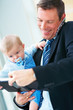 Portrait of smiling young business man holding a cute baby