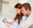 Happy young couple holding a sonogram of their unborn child