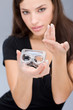 Woman holding contact lenses cases and lens; focus on container Woman holding contact lenses cases and lens; focus on container